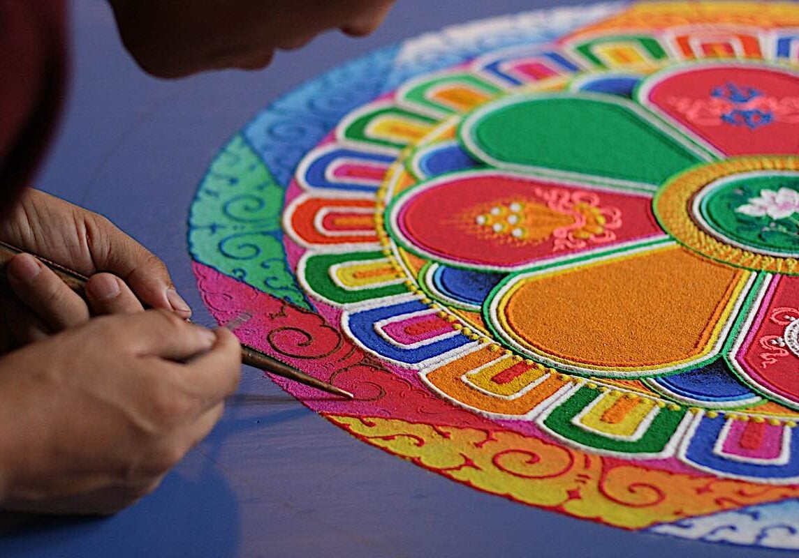 Buddha-Weekly-Creating a sand mandala is an act of faith concentration meditation patience and energy dreamstime_xxl_18837812-Buddhism A Tibetan monk diligently creates a sand mandala — a devotional act that shows faith (in the teachings) sufficient to spend days creating an impermanent mandala wit full concentration and meditative attention — and certainly mindfulness! — only at the end to sweep the mandala into the river water (demonstrating impermanence.)