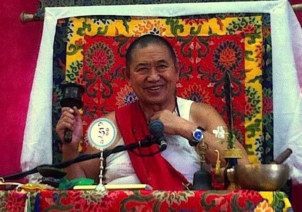 Buddha-Weekly-H.E. Garchen Rinpoche at Teachings Spins Wheel from Galgamani-Buddhism H.E. Garchen Rinpoche teaching with spinning prayer wheel in right hand.
