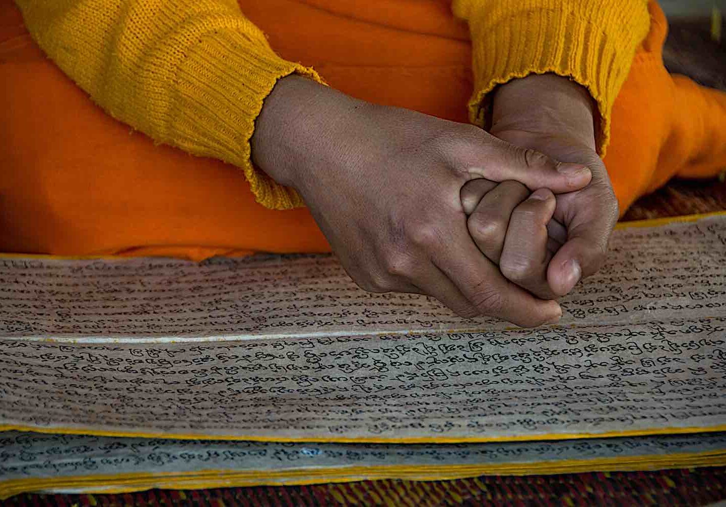 Novice monk in Laos reading Buddhist Dharma texts in Sanskrit.