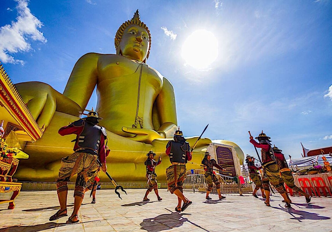 Buddha-Weekly-Warrior style in front of Buddha Statue at Wat Muang Buddhist Temple-Buddhism Angthong, Thailand - July 15, 2014: Actors performing fighting in ancient warrior style in front of large golden Buddha Image to celebrate Buddhist event at Wat Muang, Buddhist temple in Angthong, Thailand.